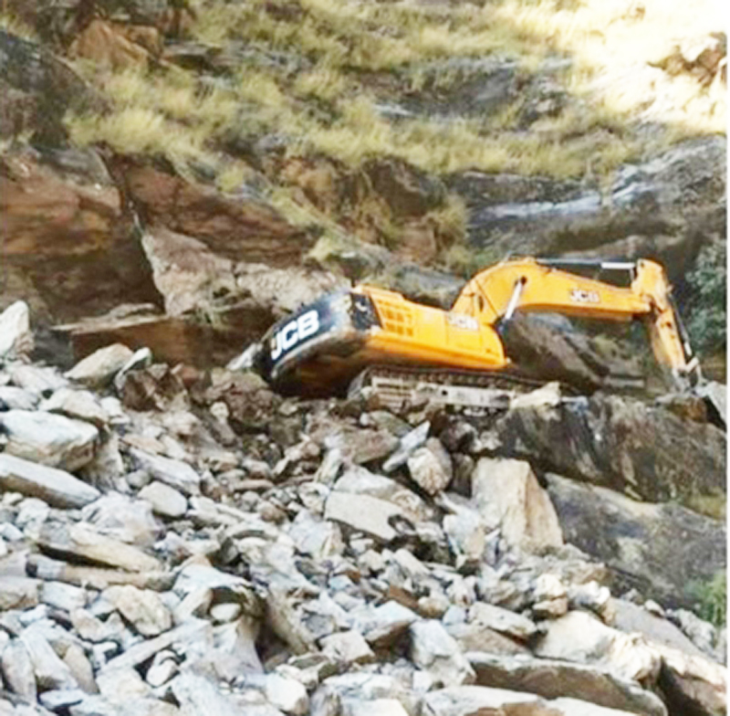An excavator trapped in landslide at Drabshalla area of district Kishtwar. —Excelsior/Tilak Raj