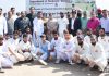 Cricket players posing with guests, coaches and other supporting staff.