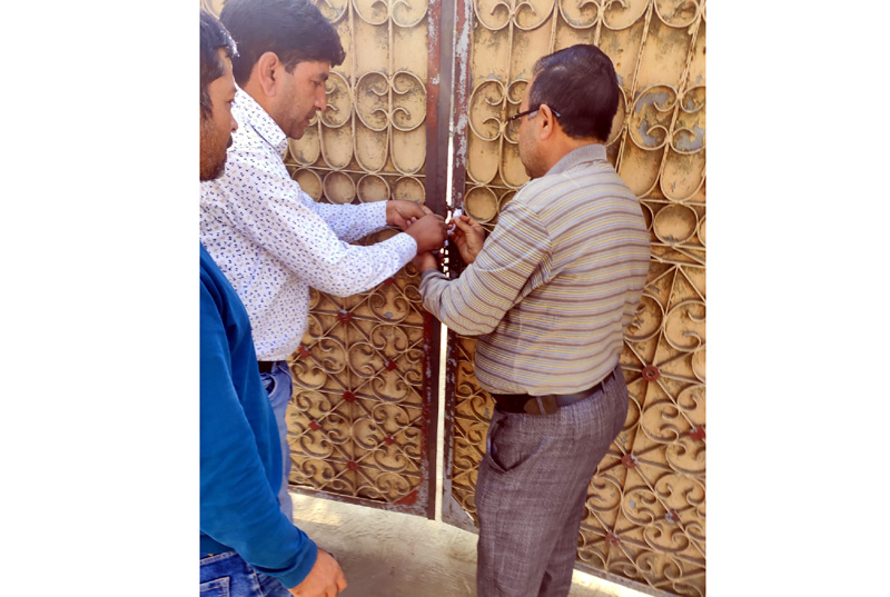 Officials sealing liquor shop. Officials sealing liquor shop.