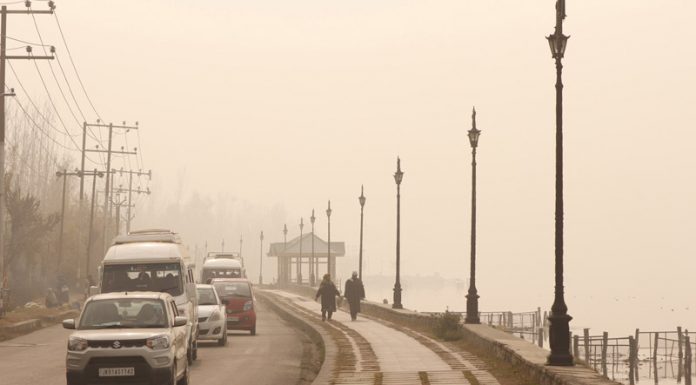 Vehicles plying amid fog in Sringar. -Excelsior/Shakeel