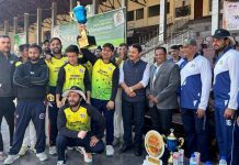Players displaying the winning trophy while posing with dignitaries at MA Stadium Jammu on Wednesday.