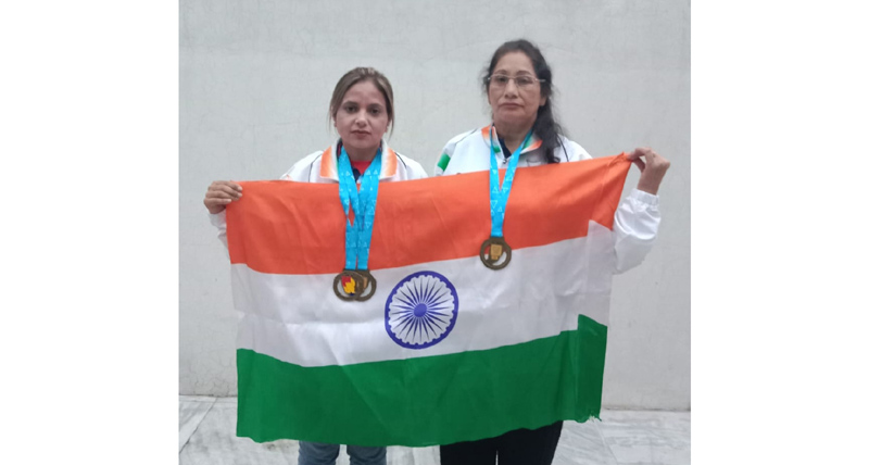 Sudesh Basotra and Shahida Parveen posing together while holding Tricolour after winning bronze medals.