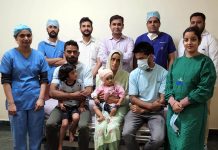Dr. Rohan Gupta and his team posing for a group photograph with a girl child after performing Cochlear Implant surgery on her at SMVDSSH.
