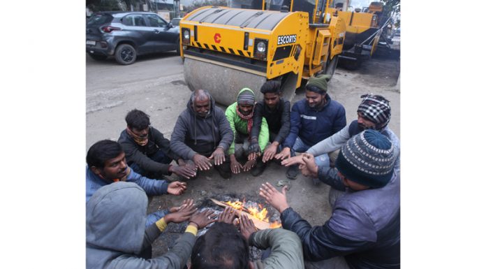 People warm themselves on a cold day in Jammu. -Excelsior/Rakesh