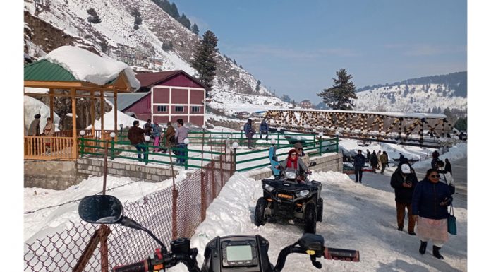 Tourists enjoying the snow at Drang in Gulmarg on Sunday. (UNI)