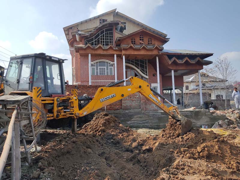Outer wall at the main gate of the former bureaucrat Farooq Renzu Shah’s residence being demolished in Friends enclave, near the airport at Srinagar.-Excelsior/Shakeel