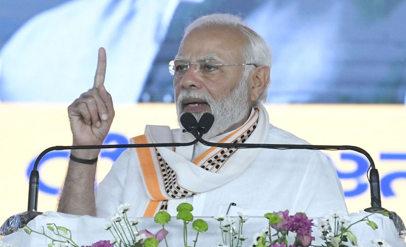 Prime Minister Narendra Modi addressing at the laying foundation stone and dedicates key development projects at Mandya, in Karnataka on Sunday. (UNI)