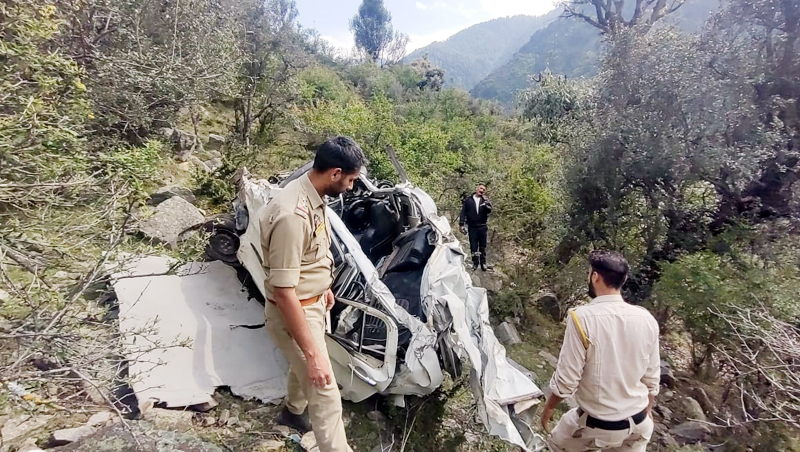 Cops inspecting mingled remains of an accident hit car in Doda on Tuesday.-Excelsior/Tilak Raj