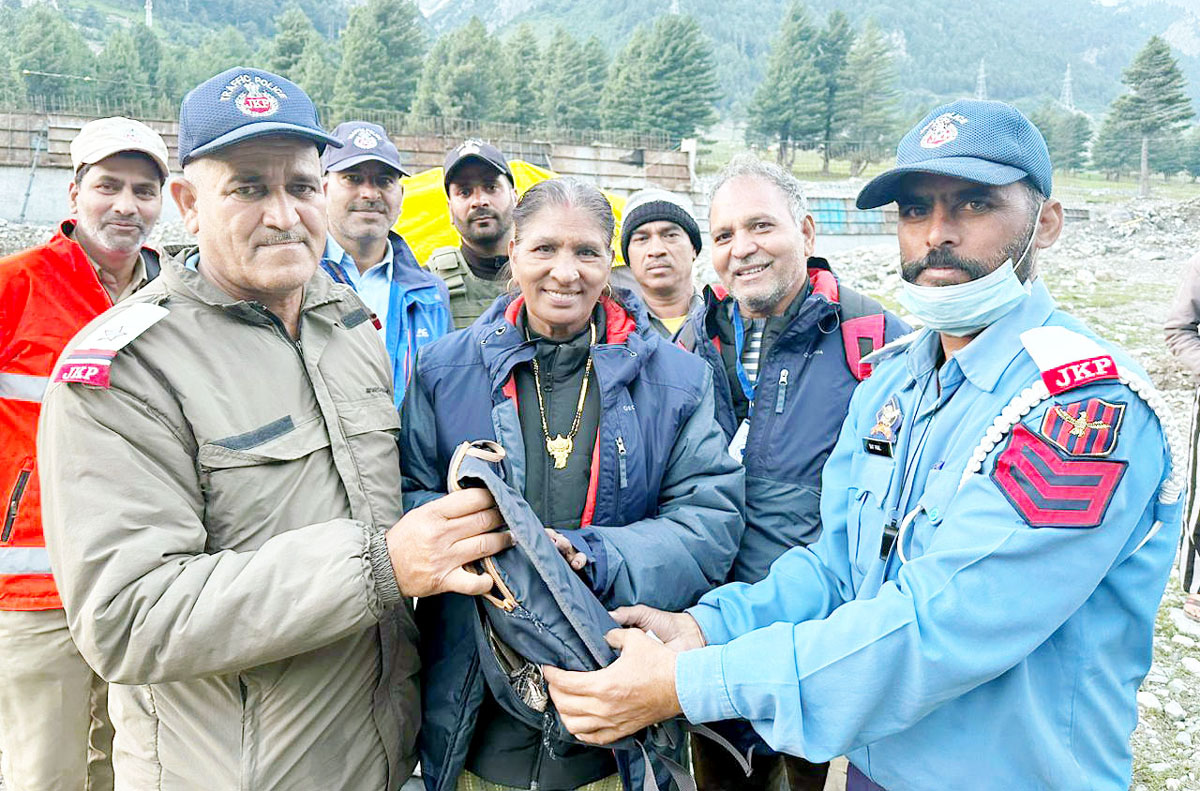 ASI Darshan Kumar and HC Satpal handing over the lost bag to its rightful owner in Kashmir on Sunday. ASI Darshan Kumar and HC Satpal handing over the lost bag to its rightful owner in Kashmir on Sunday.