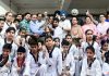 Budding Taekwondo players posing for photograph with dignitaries.