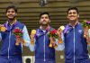 Indian shooters posing with team gold medal.