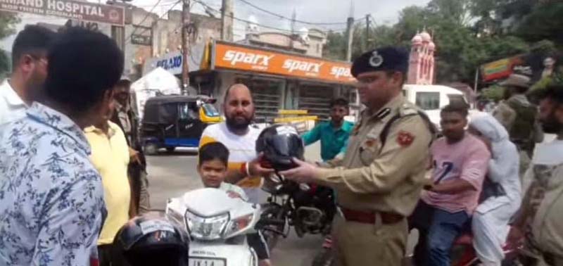 SSP Udhampur, Dr Vinod Kumar, distributing crash helmets to commuters during a road safety campaign on Sunday. SSP Udhampur, Dr Vinod Kumar, distributing crash helmets to commuters during a road safety campaign on Sunday.