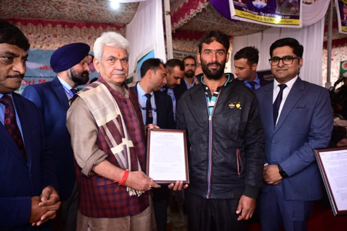LG Manoj Sinha handing over land allotment letter to a beneficiary at Bandipora.