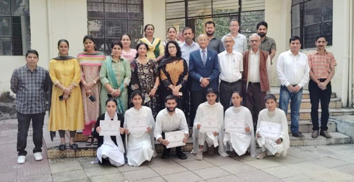 Students, faculty members and others posing for a group photograph during a seminar on promotion of Hindi at Govt GLDM Degree College, Hiranagar.