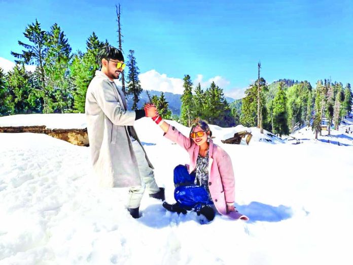 Tourists enjoy snow at Guldanda in Bhaderwah area of Doda district. -Excelsior/Tilak Raj