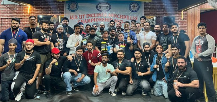 Lifters posing with dignitaries by displaying medals.