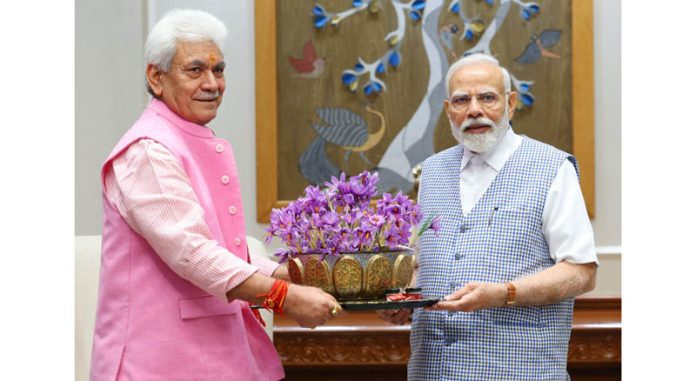 Lt Governor Manoj Sinha presenting saffron flowers to Prime Minister Narendra Modi in New Delhi on Tuesday. (UNI) Lt Governor Manoj Sinha presenting saffron flowers to Prime Minister Narendra Modi in New Delhi on Tuesday. (UNI)