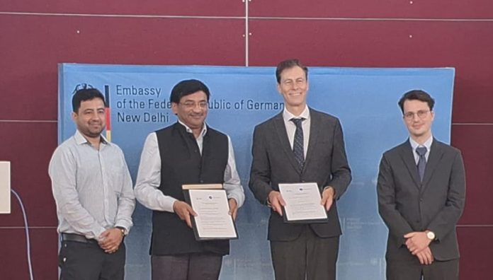 Prof Manoj Singh Gaur and Dr Michael Harms displaying the copies of MoU signed between IIT Jammu and DAAD Germany.