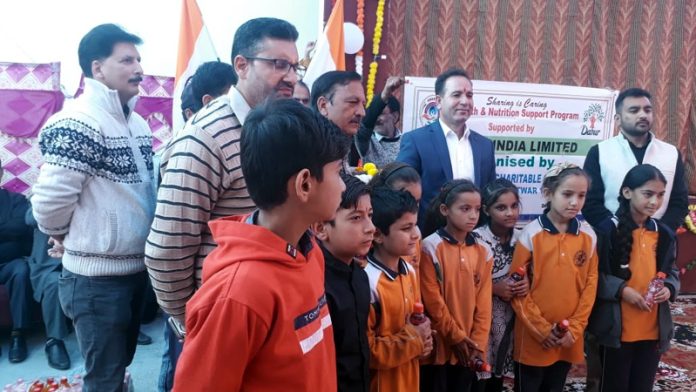 Former Minister and BJP general secretary, Sunil Sharma with members of SRCO during distribution of nutritious items among students in Kishtwar on Sunday.