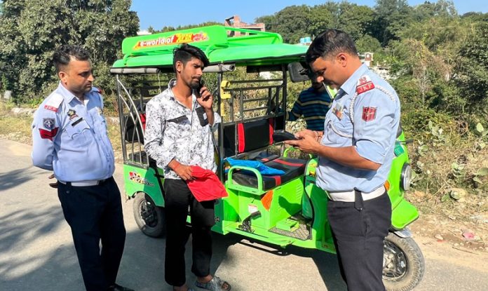 Traffic Police officials challaning an e-Rickshaw in Jammu on Wednesday. Traffic Police officials challaning an e-Rickshaw in Jammu on Wednesday.