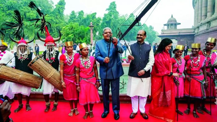 Vice President Jagdeep Dhankhar and Lok Sabha Speaker Om Birla with folk artists after paying tribute to Bhagwan Birsa Munda during celebration of 'Janjatiya Gaurav Divas' at Parliament House complex, in New Delhi.
