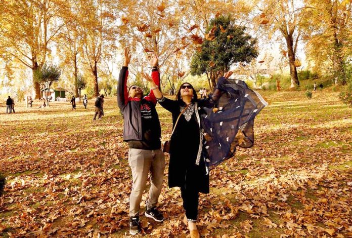 A couple enjoys autumn season in a garden at Srinagar on Monday. -Excelsior/Shakeel