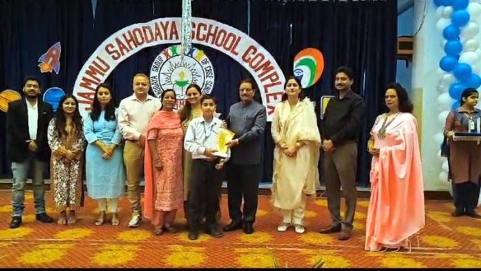 Chairman of Rich Harvest School, Thakur Gulchain Singh Charak presenting prize to a winner of Painting Competition in presence of other guests.
