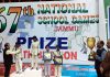 Players posing on podium with certificates and medals with dignitaries. 