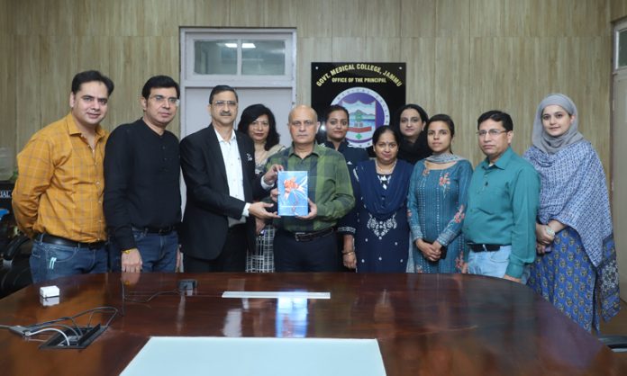 Principal GMC Jammu Dr Ashutosh Gupta unveiling a book in his office chamber.