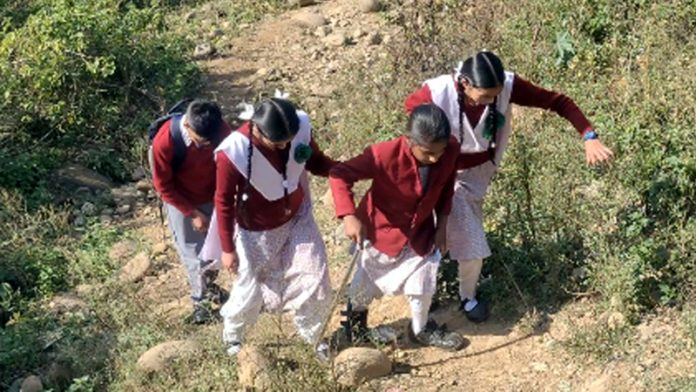 Physically challenged Kajal being helped by other students to reach school.