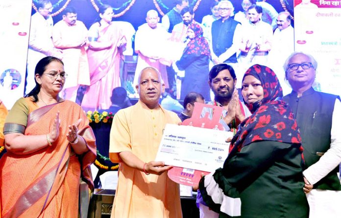 Uttar Pradesh Chief Minister Yogi Adityanath distributing free LPG cylinder refill under the 'Pradhan Mantri Ujjwala Yojana' campaign on the occasion of Dhanteras, in Lucknow on Friday. (UNI)