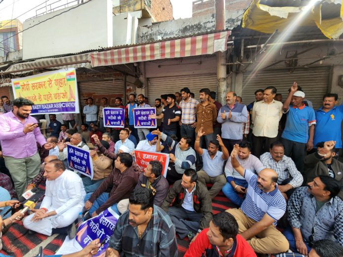 Traders protesting outside their shops in Nai Basti area on Tuesday. -Excelsior/Rakesh