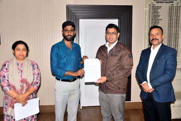 DC Rajouri giving cheque to a beneficiary.