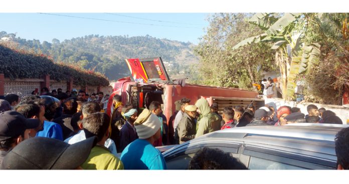 People rescue injured passengers trapped in mini-bus after accident near Rajouri. -Excelsior/Amit Sharma