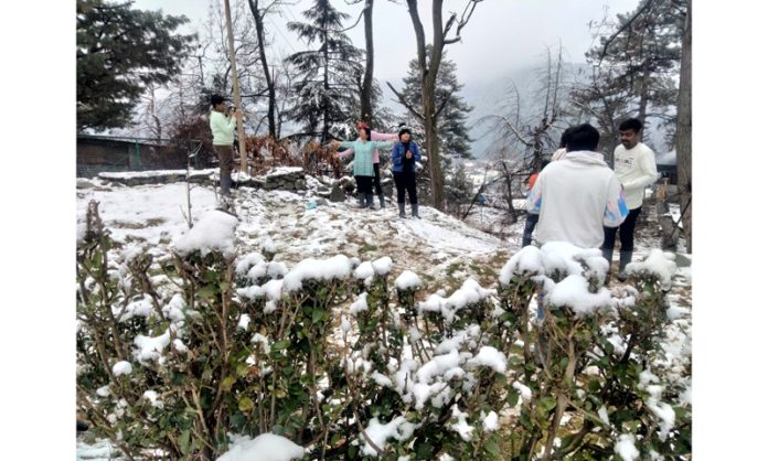 Tourists enjoying after a fresh snowfall in Tangmarg area of of Baramulla on Sunday. (UNI)