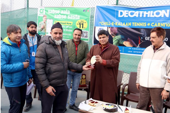 Winner being presented trophy during 'Decathlon Chillai-Kalan Tennis Carnival' at Gindun Stadium Rajbagh on Sunday.-Excelsior/Shakeel
