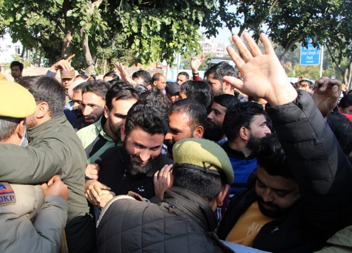 Police officials restraining the movement of protesting F&ES job aspirants in Jammu on Wednesday.