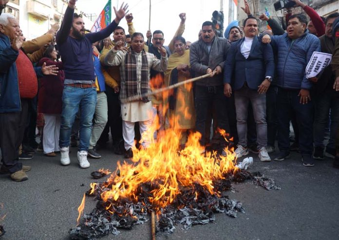 BJP activists led by district president, Parmod Kapahi and former Minister, Sat Sharma torching effigy of Congress during a protest at Kachi Chawni on Thursday. -Excelsior/Rakesh BJP activists led by district president, Parmod Kapahi and former Minister, Sat Sharma torching effigy of Congress during a protest at Kachi Chawni on Thursday. -Excelsior/Rakesh