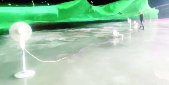 Electric fans used during night to encourage the freezing process on the ice rink. -Excelsior/Basharat Ladakhi