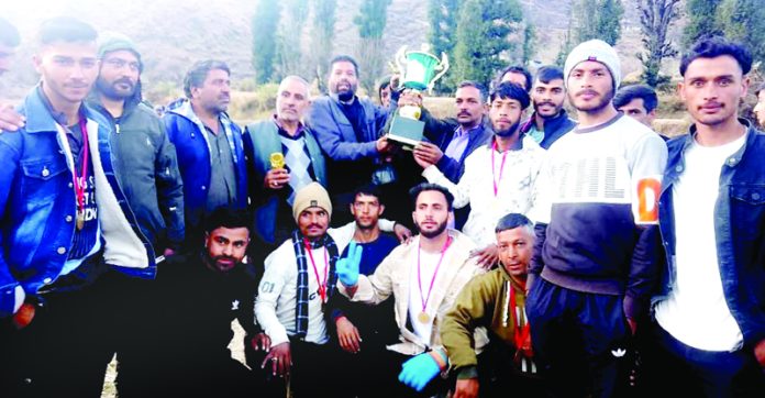 Winning cricket team posing with trophy on Sunday.