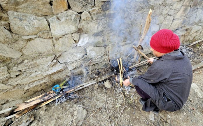 A man using fire to unfreeze water pipes in Baramulla. -Excelsior/Aabid Nabi