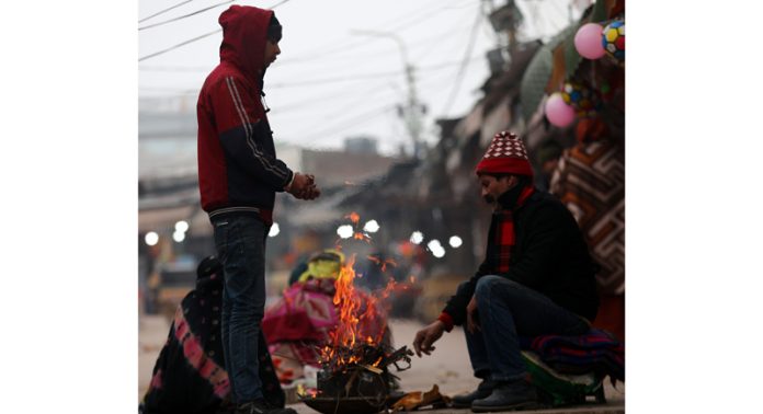 Amidst severe cold, people lit bonfire to warm themselves in Jammu on Tuesday. - Excelsior/Rakesh