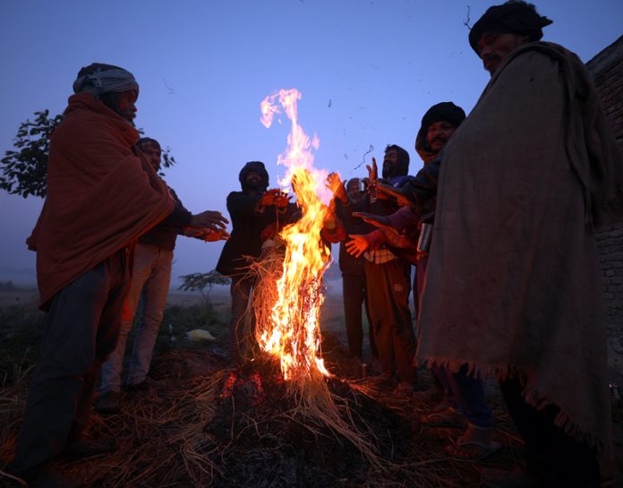 People warm themselves around bonfire on the outskirts of Jammu on Sunday. - Excelsior/Rakesh
