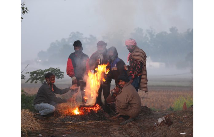 Amidst chilling cold and fog, people lit fire for warming themselves in Jammu's outskirts on Tuesday. -Excelsior/Rakesh Amidst chilling cold and fog, people lit fire for warming themselves in Jammu's outskirts on Tuesday. -Excelsior/Rakesh