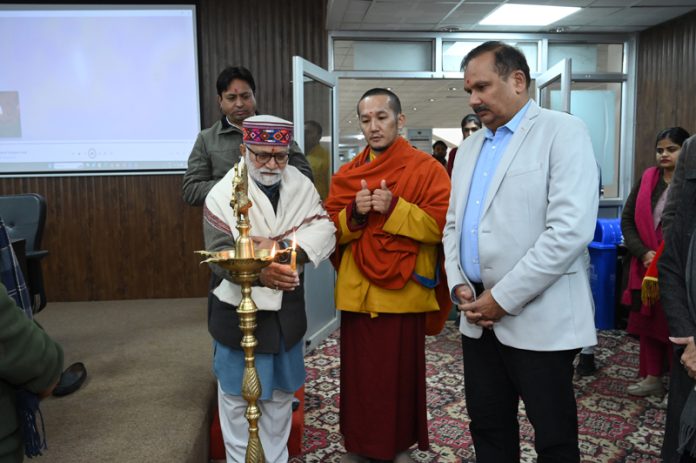 Parshotam Dadhichi lighting ceremonial lamp while CUJ VC and Palga Rinoche look on.