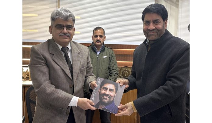 Former cultural diplomat of India, Balwant Thakur presenting a book to Chief Secretary Atal Dulloo.