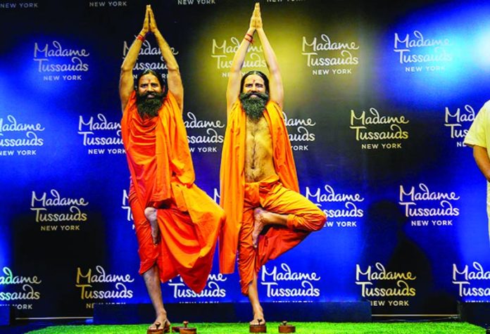 Yoga guru Ramdev poses for photos with his wax figure unveiled by Madame Tussauds New York, in New Delhi.