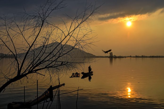 Different hues of sky, accompanied by vibrant reflections captured along Dal lake during Sunset. — Excelsior/Shakeel