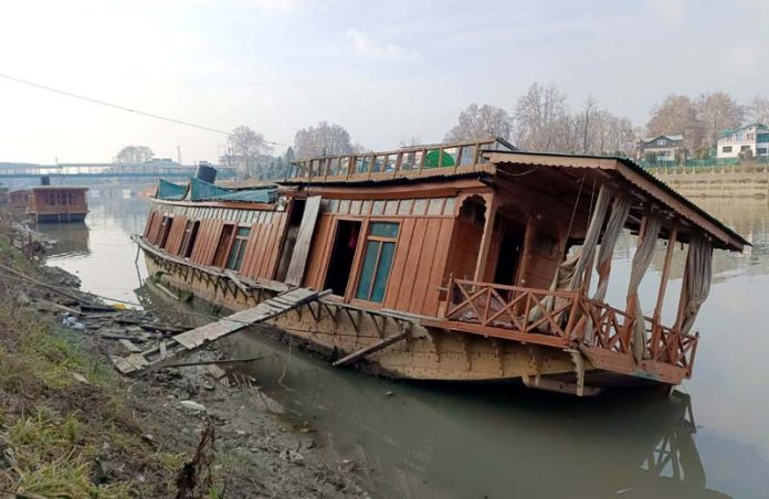 Damaged houseboat in river Jhelum at Rajbagh on Tuesday. -Excelsior/Shakeel Damaged houseboat in river Jhelum at Rajbagh on Tuesday. -Excelsior/Shakeel