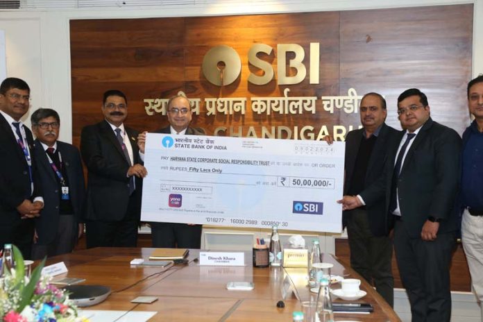 Dinesh Khara, Chairman, SBI presenting cheque to Dr Randeep Singh Poonia, DG Health Services, Haryana Government on Friday.
